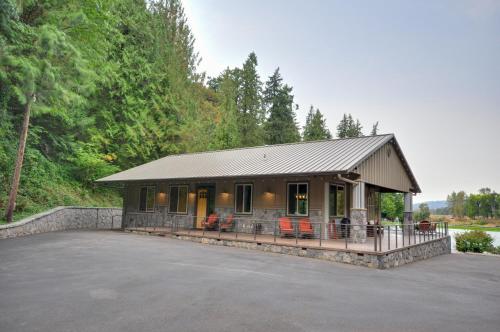 a house with a porch and chairs in a parking lot at Luxurious Waterfront Retreat with Private Pond! in Ridgefield