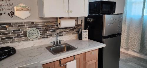 a kitchen with a sink and a refrigerator at Sweet Studio in Sarasota in Sarasota