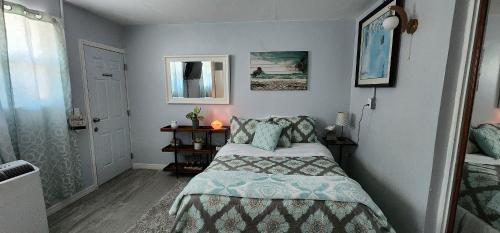 um pequeno quarto com uma cama e um espelho em Sweet Studio in Sarasota em Sarasota