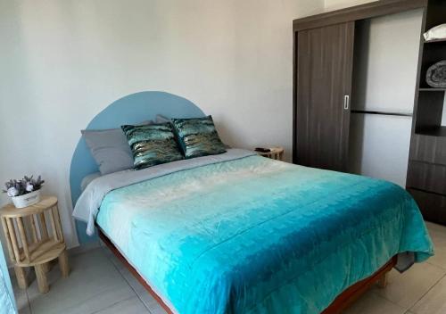 1 dormitorio con 1 cama con cabecero azul en Departamento climatizado excelente ubicación, en Veracruz