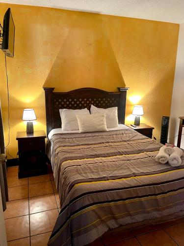 a bedroom with a large bed with two lamps on tables at Hotel y Restaurante San Fernando. in Jocotenango