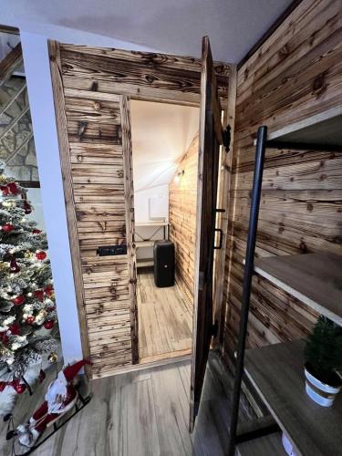 a room with a wooden wall and a door at Chata pod Starou Horou in Trstená