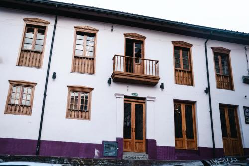 un edificio blanco con puertas y ventanas de madera en Casa Dreamer Bogotá en Bogotá