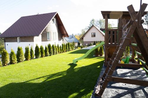 a playground with a slide in a yard at Chata pod Starou Horou in Trstená