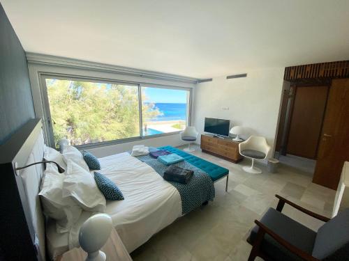 une chambre avec un lit et une grande fenêtre dans l'établissement Villa d'architecte, accès privé plage, accès port, à Sainte-Maxime