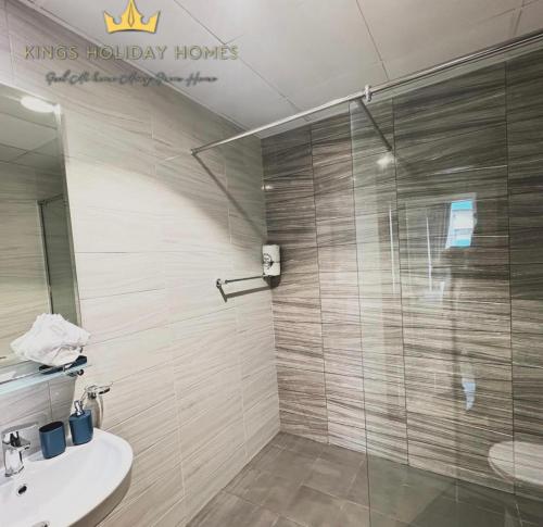 a bathroom with a glass shower and a sink at Dunya tower Royal suite Burj Khalifa street, Kings in Dubai