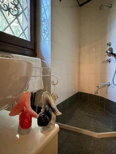 un bagno con lavandino e doccia con due statuine di ☆Lovely view of Florence in Stilish Designed Apt☆ a Fiesole