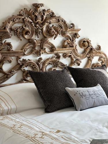 un letto bianco con cuscini neri accanto a una parete bianca di ☆Lovely view of Florence in Stilish Designed Apt☆ a Fiesole