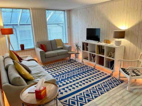 a living room with a couch and a tv at Contemporary City Centre 3 bedroom apartment in Sheffield