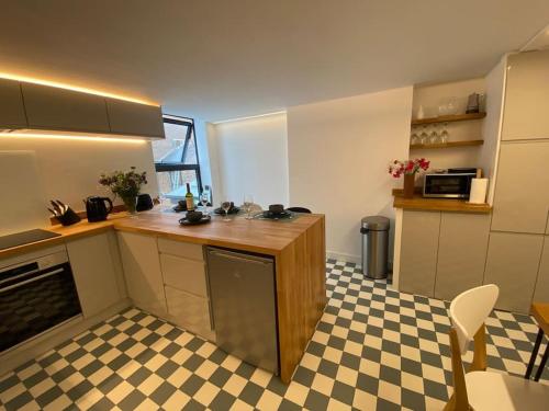uma cozinha com um balcão e um piso xadrez em Contemporary City Centre 3 bedroom apartment em Sheffield