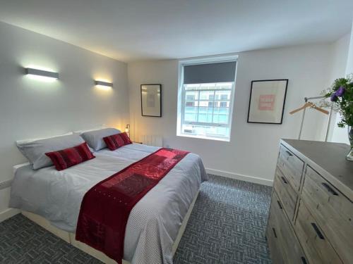 a bedroom with a large bed with red pillows at Contemporary City Centre 3 bedroom apartment in Sheffield