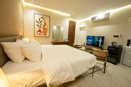 a bedroom with a white bed and a television at شقق درر المفروشة تصميم إيطالي دخـول ذاتي in Riyadh