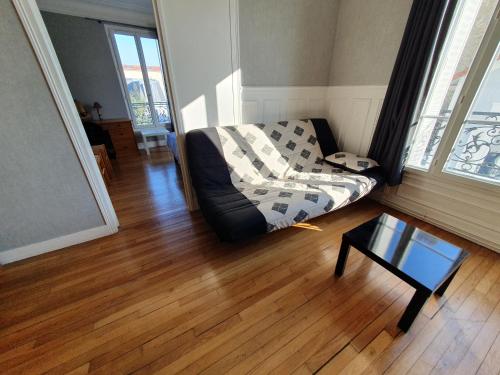 sala de estar con sofá y mesa de centro en 2 chambres à 10 min du centre de Paris, en Bois-Colombes