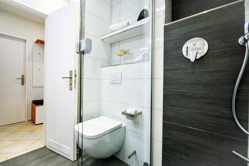 een badkamer met een toilet en een douche bij Strandhochhaus SG10 in Cuxhaven