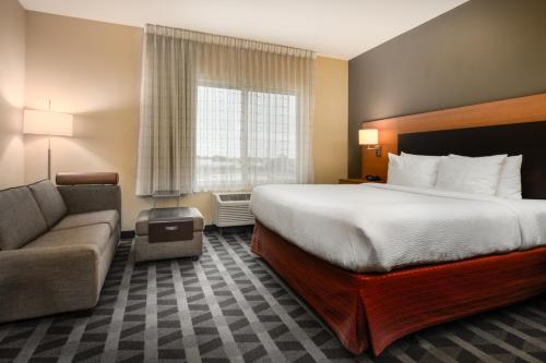 a hotel room with a bed and a couch at TownePlace Suites by Marriott Cleveland in Cleveland