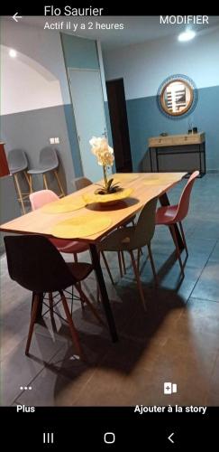 drewniany stół z krzesłami i wazon z kwiatami w obiekcie Le temps d'une ile w mieście La Saline