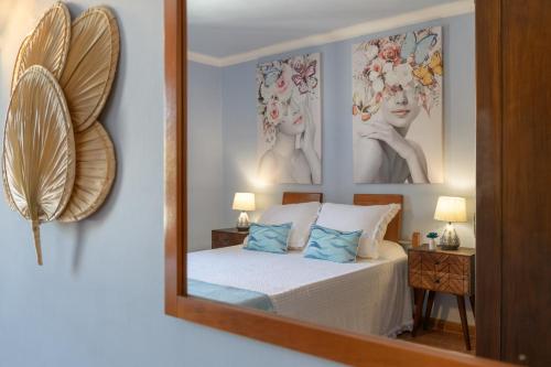 a mirror reflecting a bedroom with a bed and two pictures at Casa Fantástica in Playa Honda