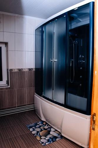 a bathroom with a glass shower with rocks on the floor at Ехо Тростяну in Slavske