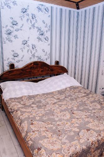 a bed with a wooden head board in a bedroom at Ехо Тростяну in Slavske