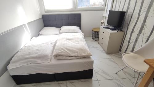 - une petite chambre avec un lit et une télévision dans l'établissement Studio27, à Wrocław