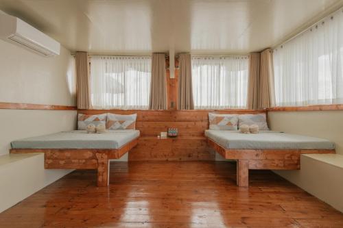 two beds in a room with two windows at Kaway Resort & Spa in Tabuelan