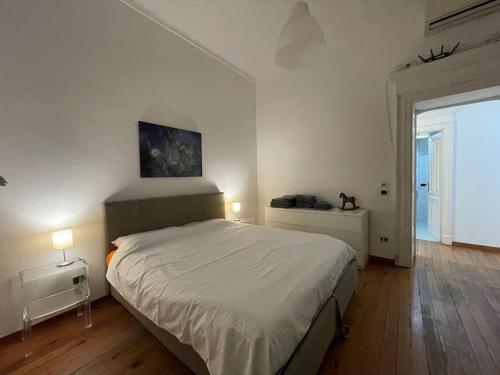 a white bedroom with a bed and a window at Appartamento centro storico in Via Palestro in Ivrea