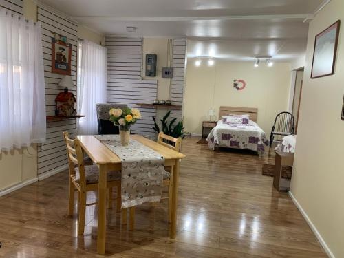 ein Esszimmer mit einem Tisch und ein Schlafzimmer in der Unterkunft MI HOGAR ES TUYO in Punta Arenas