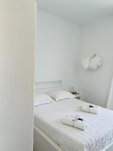 a white bed with two white towels on it at EOS - Appartement de charme et confort pour 4 personnes prés de la plage et du coeur de Koufonissi in Koufonisia