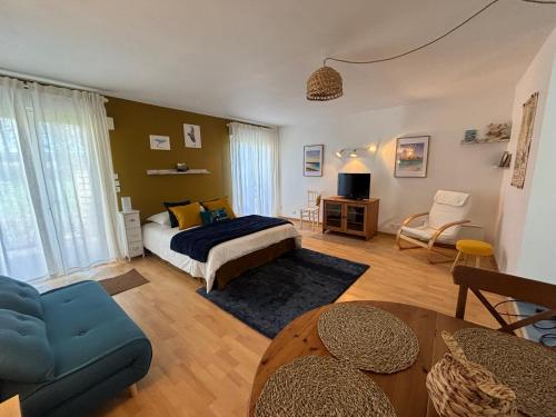 ein Schlafzimmer mit einem Bett und ein Wohnzimmer in der Unterkunft Les gîtes du manoir de Port Cadic in Rédené