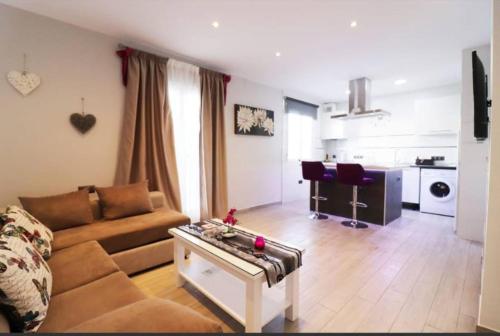 ein Wohnzimmer mit einem Sofa und einem Tisch in der Unterkunft 2 bedrooms appartement with wifi at Frigiliana 7 km away from the beach in Frigiliana