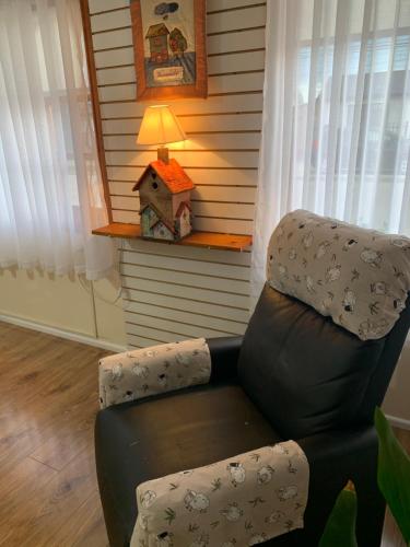 a reclining chair in a living room with a lamp at MI HOGAR ES TUYO in Punta Arenas