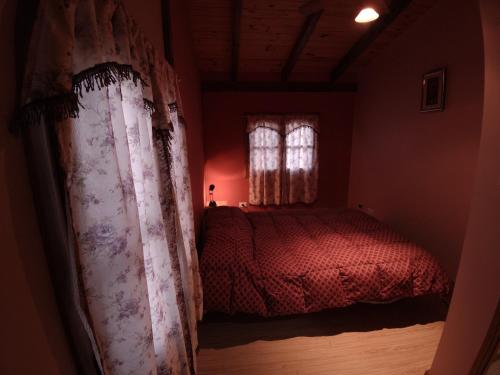 a bedroom with a red bed and a window at Cabañas Don Carlos in El Hoyo