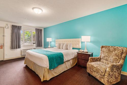 a bedroom with a large bed and a chair at Howard Johnson by Wyndham Traverse City in Traverse City