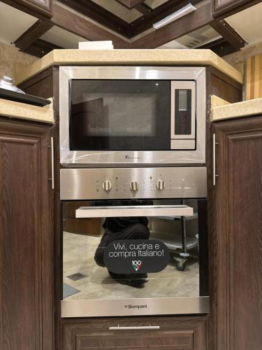 a microwave oven in a cabinet in a kitchen at لاڤانا in Unayzah