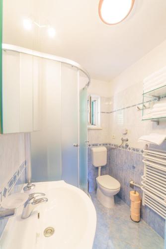 a bathroom with a white sink and a toilet at Villa Vicko in Sumartin