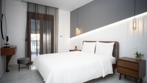 een slaapkamer met een wit bed en een raam bij Mountain Vista Residence in Kalabaka