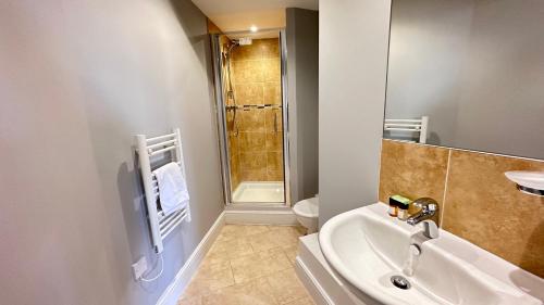 uma casa de banho com um lavatório, um WC e um chuveiro em Cosmo Suites em Bracknell