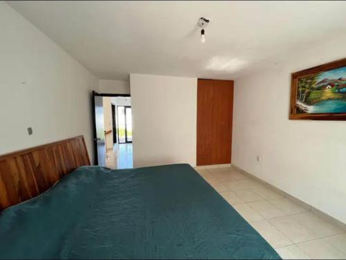 - une chambre avec un lit et une couverture verte dans l'établissement Chakalito, à Tonalá