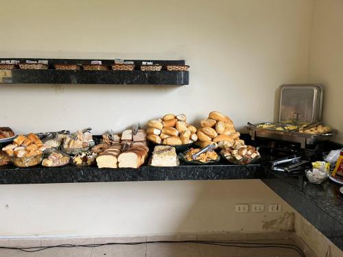 une étagère remplie de nombreux types de pain différents dans l'établissement Hotel Vila dos Pescadores, à Aparecida