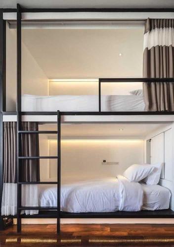 2 Etagenbetten mit weißer Bettwäsche und Kissen darauf in der Unterkunft Stay cool in Warschau