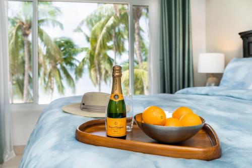 a bottle of champagne and a bowl of oranges on a bed at Callie Kai at Kaibo Yacht Club in Driftwood Village