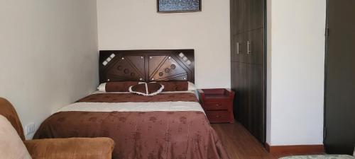 1 dormitorio con 1 cama grande y cabecero de madera en Apartamento confort centro, en Pasto