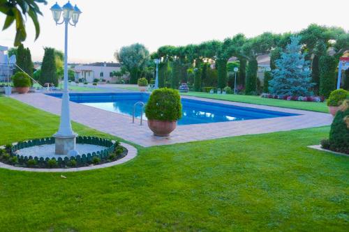 una piscina con un palo della luce nell'erba di 5 bedrooms house with private pool jacuzzi and terrace at Salamanca a Villamayor