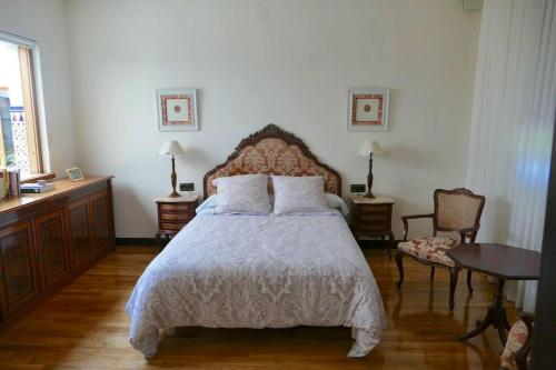 een slaapkamer met een bed en een tafel en stoelen bij 5 bedrooms house with private pool jacuzzi and terrace at Salamanca in Villamayor