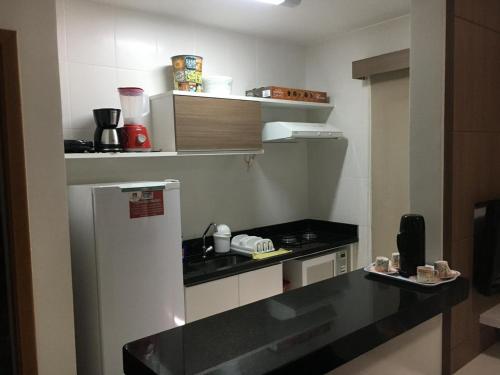 Una pequeña cocina con encimera y refrigerador. en Veredas do Rio Quente Apart, en Rio Quente