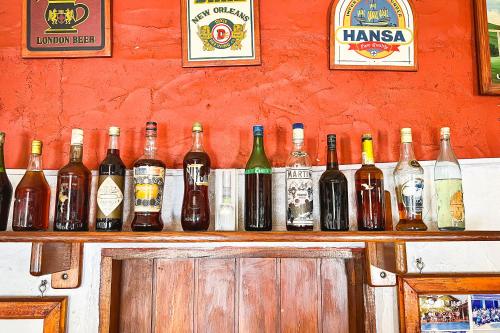 a bunch of bottles of wine sitting on a bar at VELINN Pousada Cesar in Santo Antônio do Pinhal
