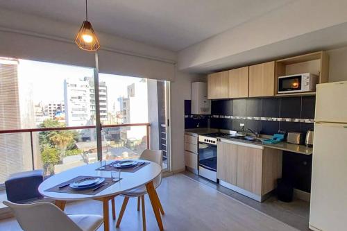 - une cuisine avec une table et des chaises blanches dans la chambre dans l'établissement Moderno apartamento en el corazón de Palermo Hollywood, à Buenos Aires