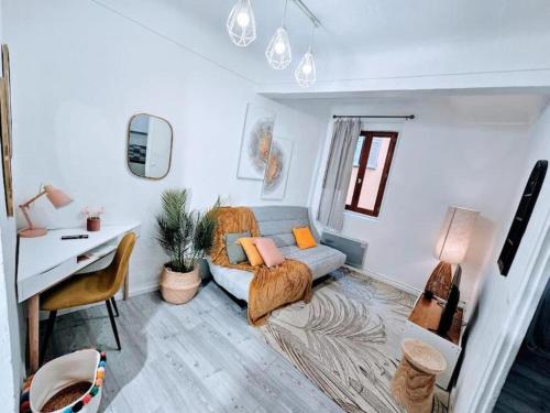 Le Nid Secret Sérénité au Cœur de Grasse في جراس: غرفة معيشة مع أريكة ومكتب