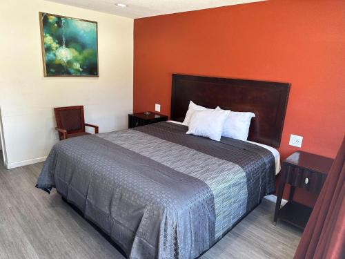 a hotel room with a bed and a red wall at Bell Manor Motel in Bell