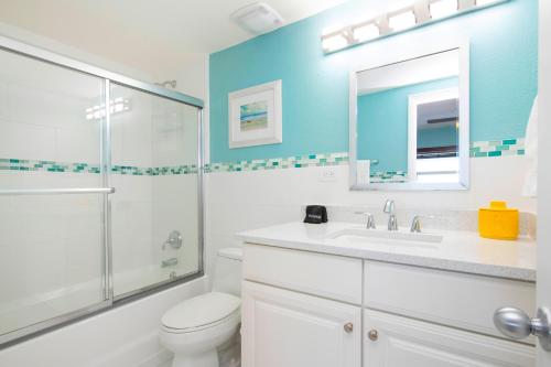 a bathroom with a shower toilet and a sink at Caribbean Paradise #29 Condo in Lambert House